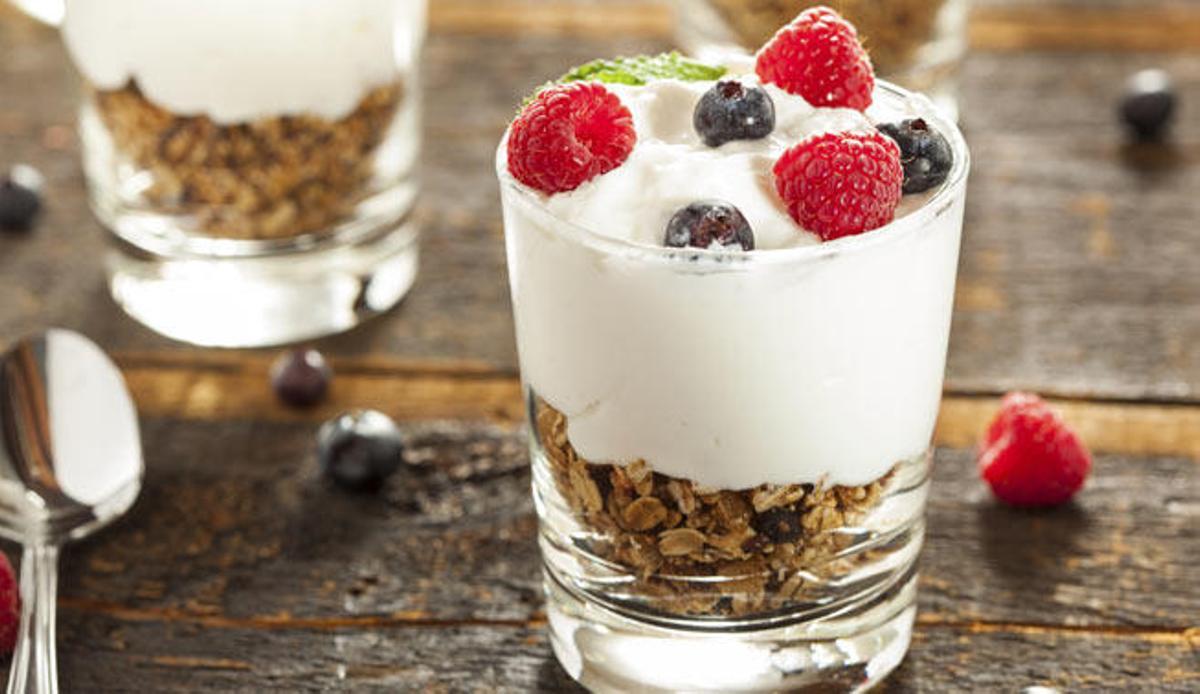 Un yogur con cereales y frutas.