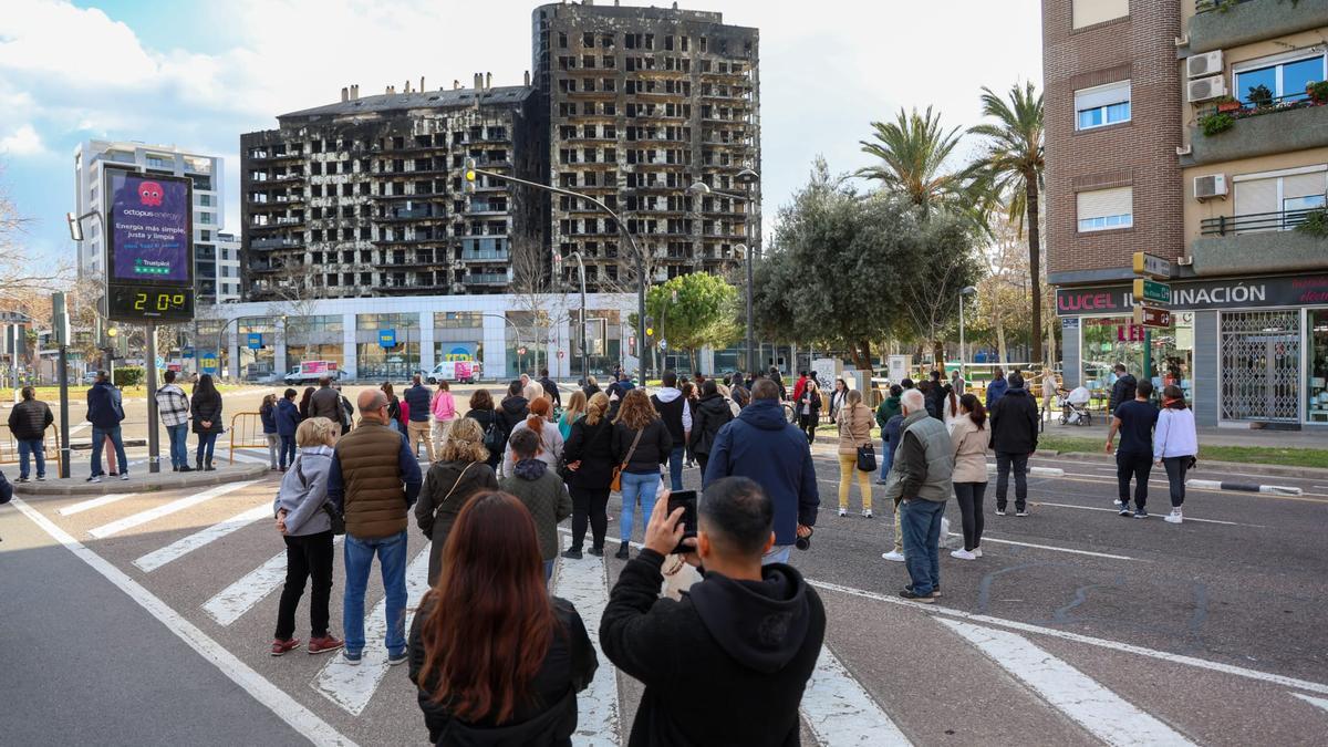 Decenas de personas contemplan el edificio quemado en Valencia en la calle Maestro Rodrigo.