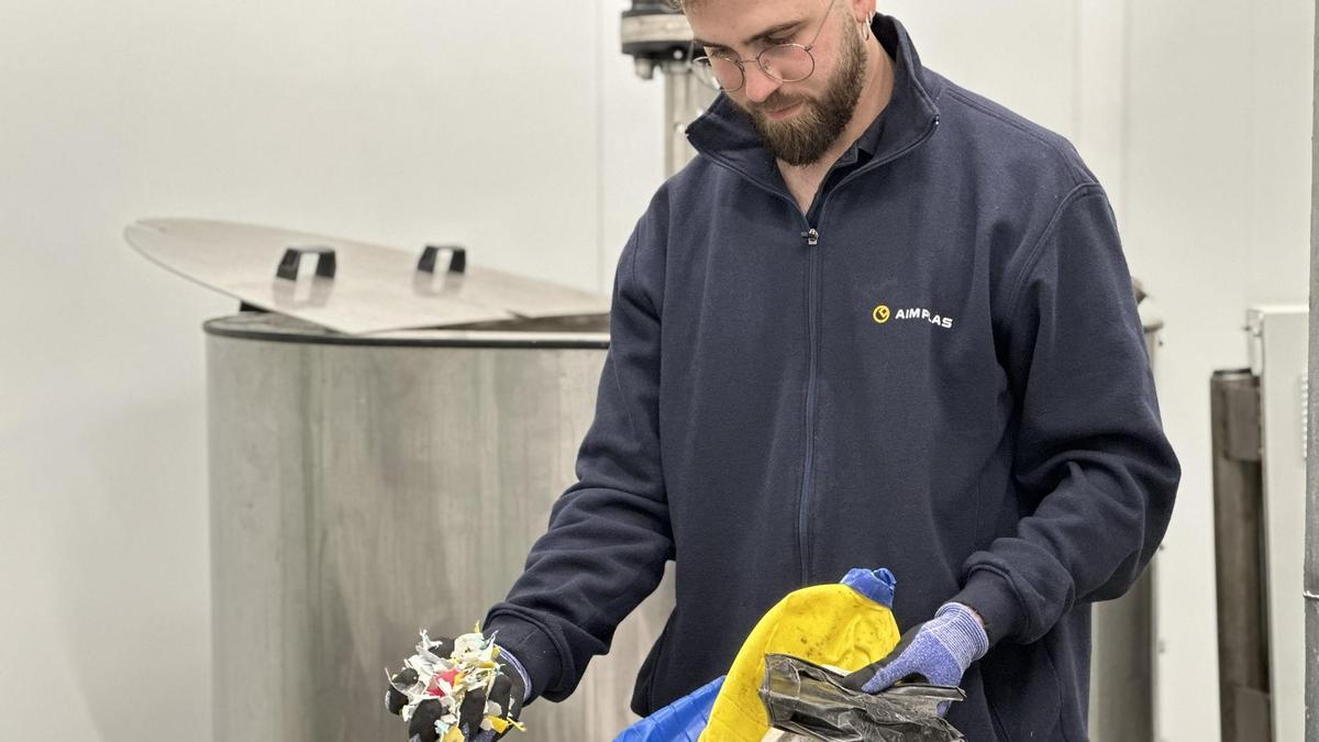 Un trabajador de Aimplas sostiene residuos plásticos en sus manos.