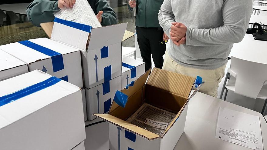 Agentes de la Guardia Civil custodian y comprueban las cajas que contienen las pruebas de oposición para ingresar al Instituto Armado