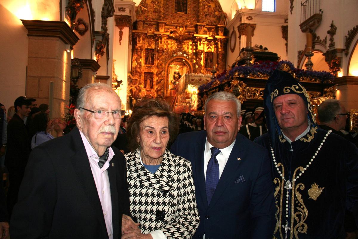 Ante el trono de la Buena Muerte posaba junto a su esposa, al presidente del Paso Azul y al Hermano Mayor del Yacente.