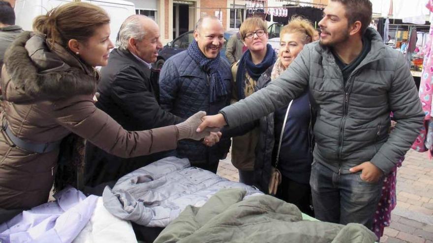 Los candidatos del PP saludan a un vendedor en uno de los puestos del mercado de Fuentesaúco.