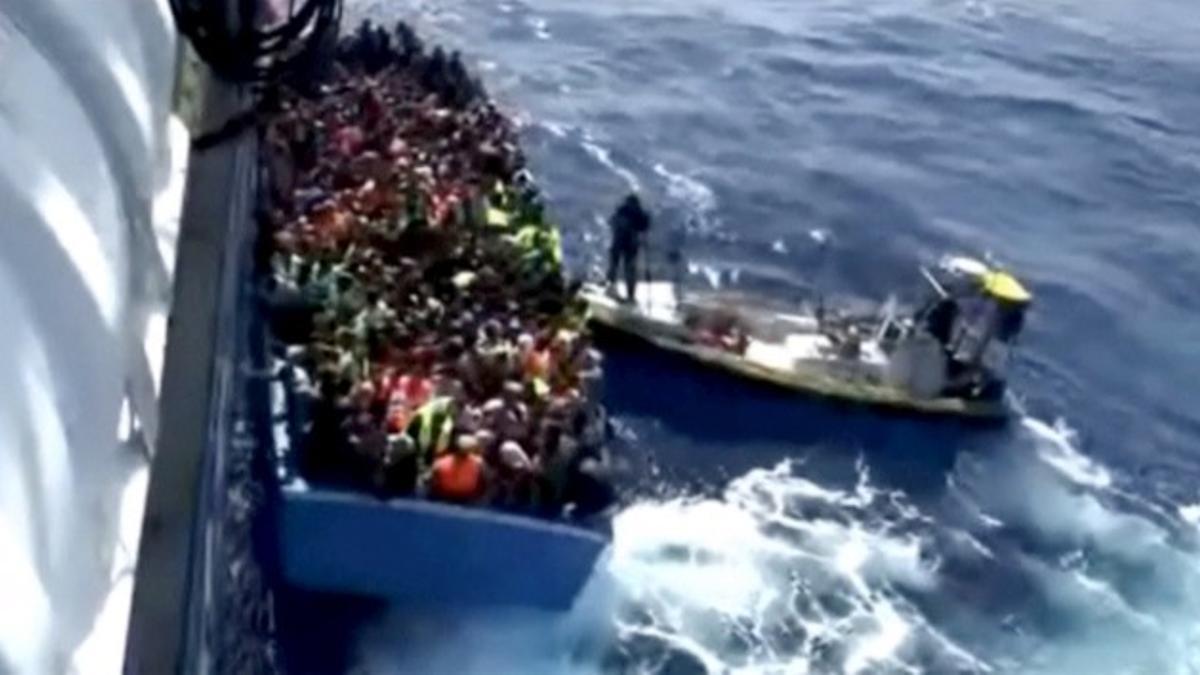 Still image from video shows a boat full of migrants next to Swedish ship Poseidon during a rescue operation in the sea off the coast of Libya