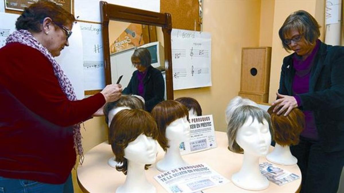 Isabel Cano (izquierda) y Berna Moreira inspeccionan unas pelucas.