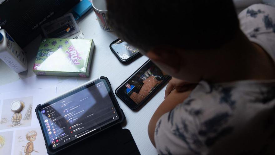 Un adolescente con ‘tablet’ y teléfono móvil.  | // EDUARDO PARRA