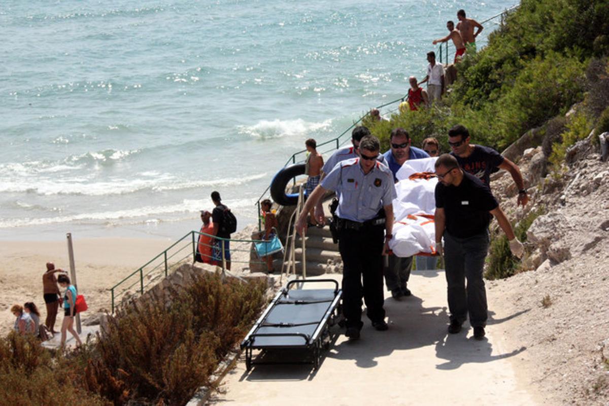 Mossos i treballadors de la funerària retiren el cadàver de la banyista morta a Salou. Mossos i treballadors de la funerària retiren el cadàver de la banyista morta a Salou.