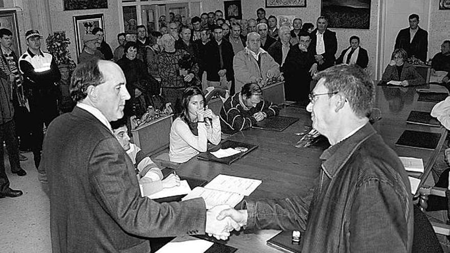 Raposeiras y Santalla sellan el acuerdo con un apretón de manos ante los vecinos, ayer.