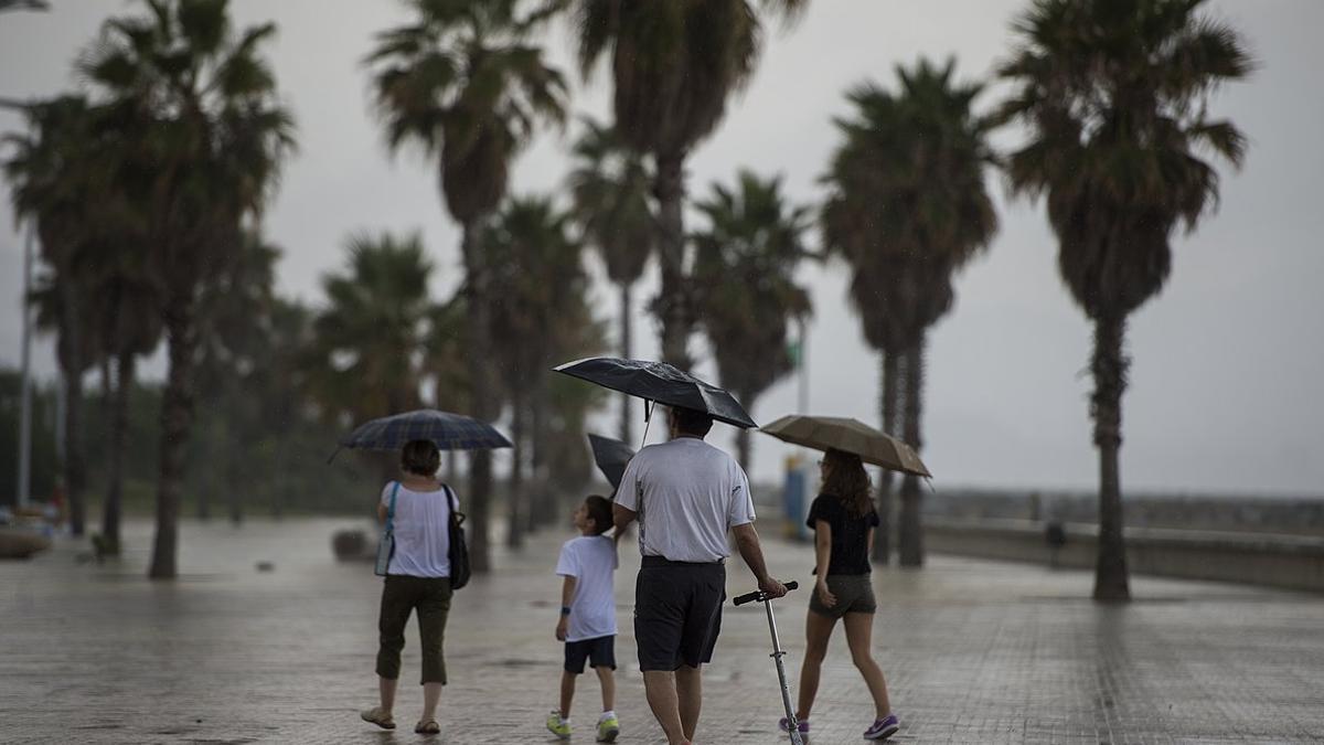 Una familia se protege de la lluvia en Barcelona.