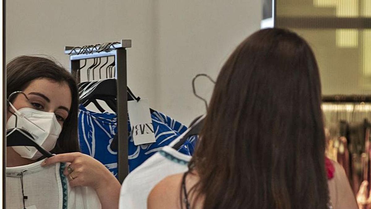 Una joven mira una prenda en una tienda de Zara.