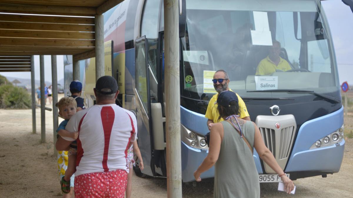 Bañistas suben al autobús que les llevará a la playa de Calblanque.