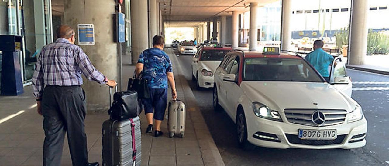 Pasajeros, ayer, se disponen a coger un taxi en la parada del aeropuerto de Lanzarote