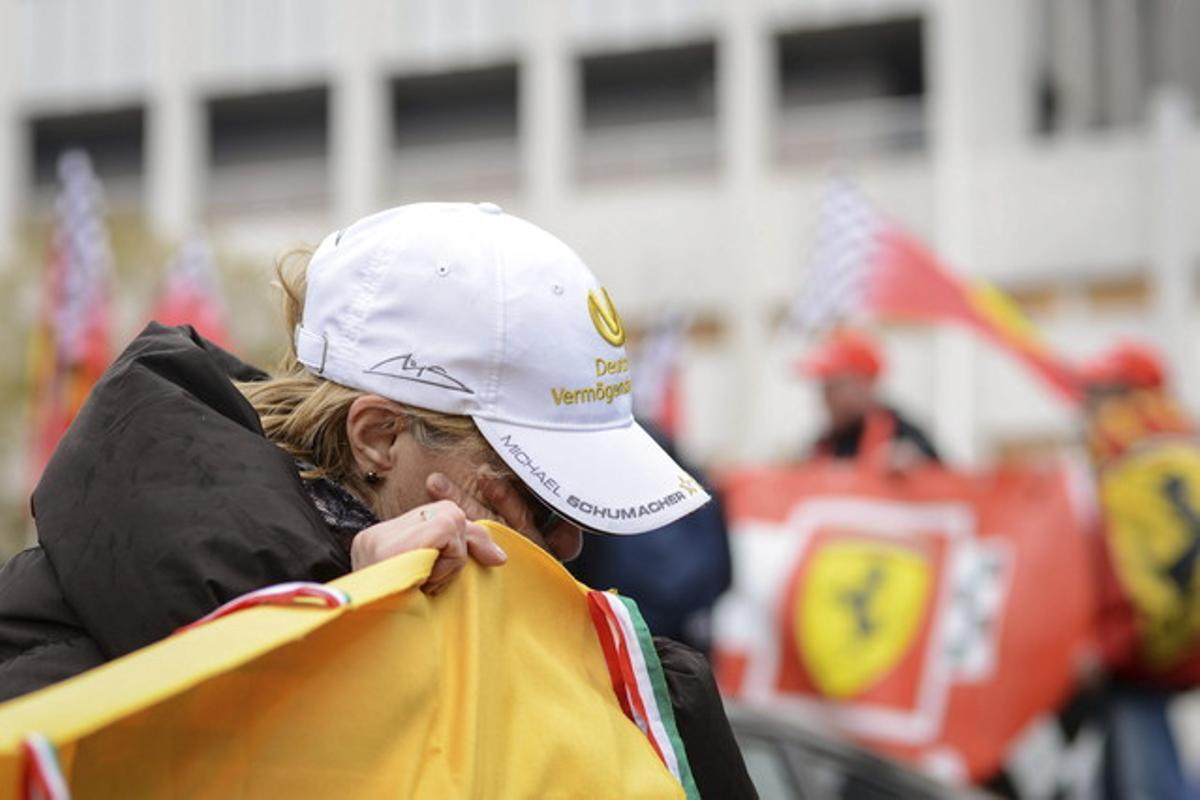 Una fan del campió de fórmula 1 plora davant de l’hospital on està ingressat Schumacher.