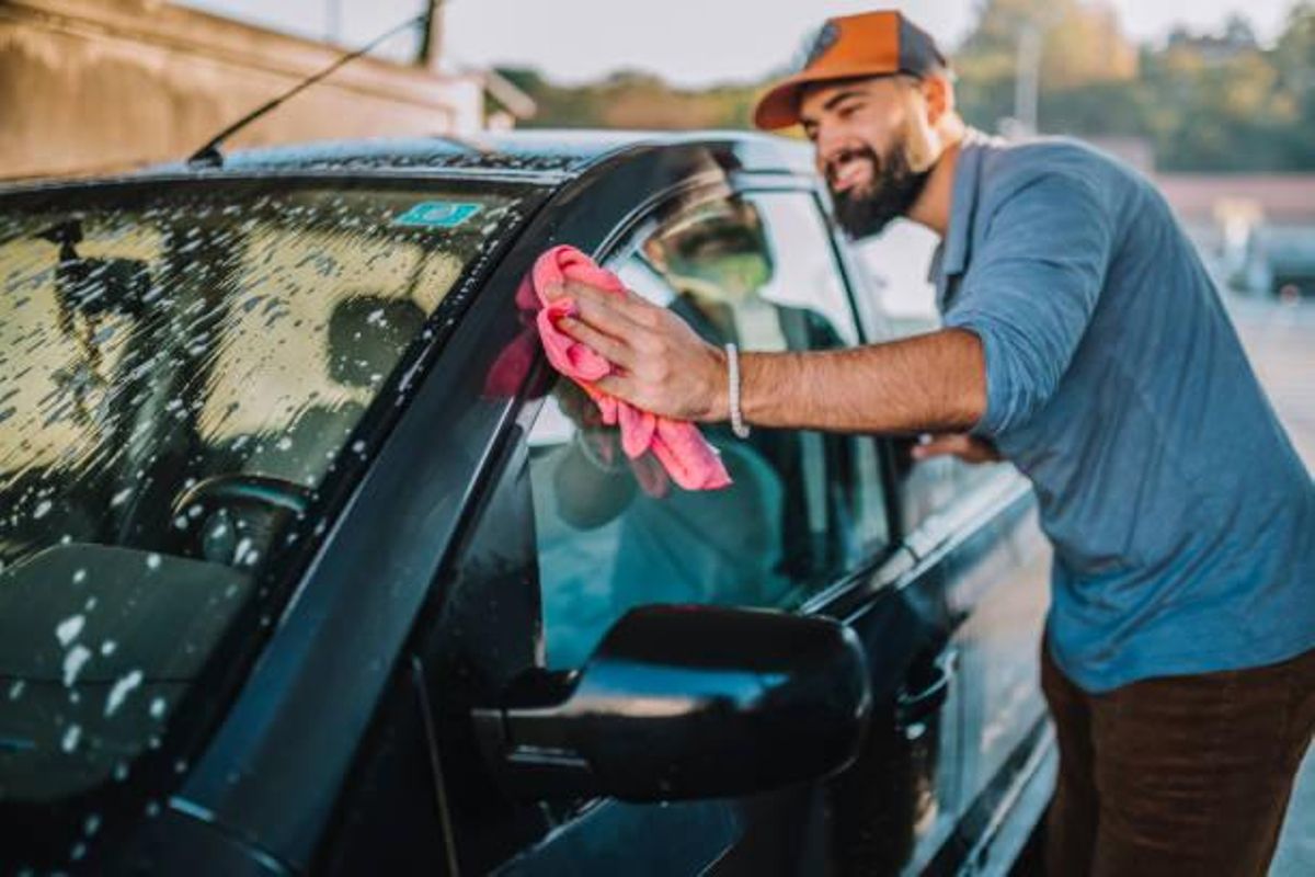 Hombre lavando un coche a mano