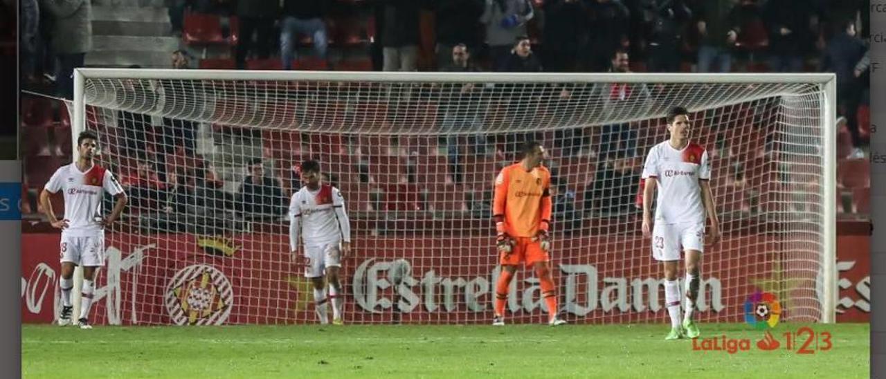 Los jugadores del Mallorca se dirigen al centro del campo tras encajar el gol de Juanpe a tres minutos del final.