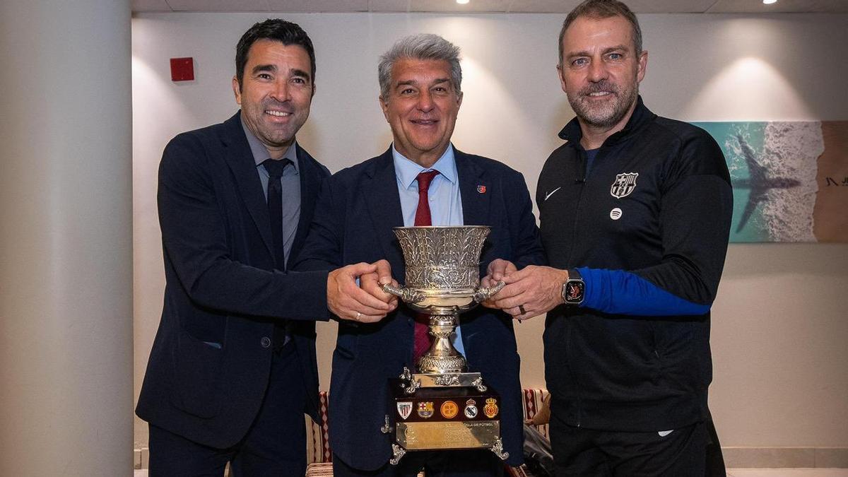 Deco, Laporta y Flick posan con la Supercopa de España.