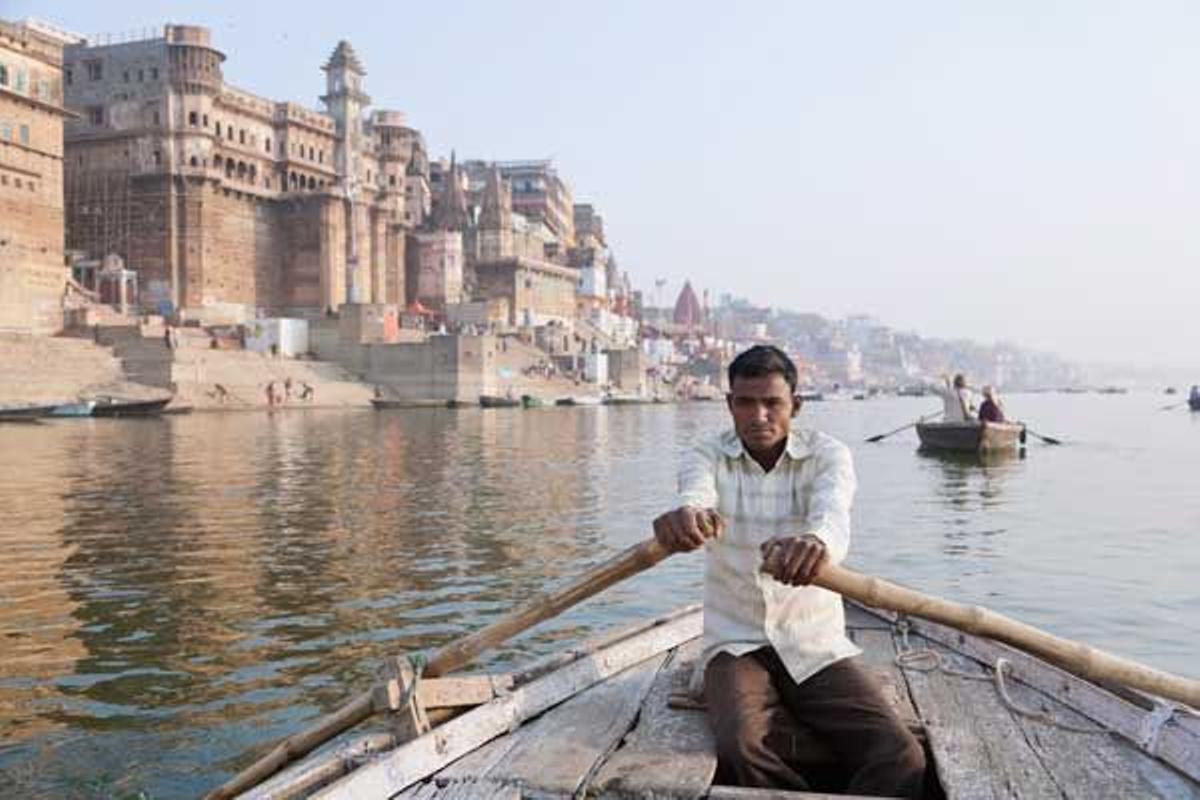Un hombre rema por el Ganges a través de los gaths.