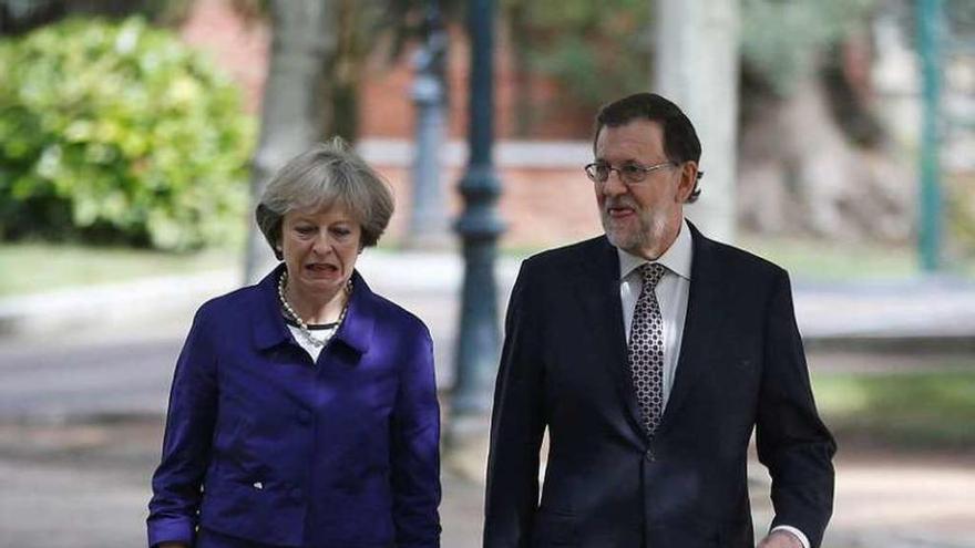 May y Rajoy, paseando por la Moncloa. // Efe