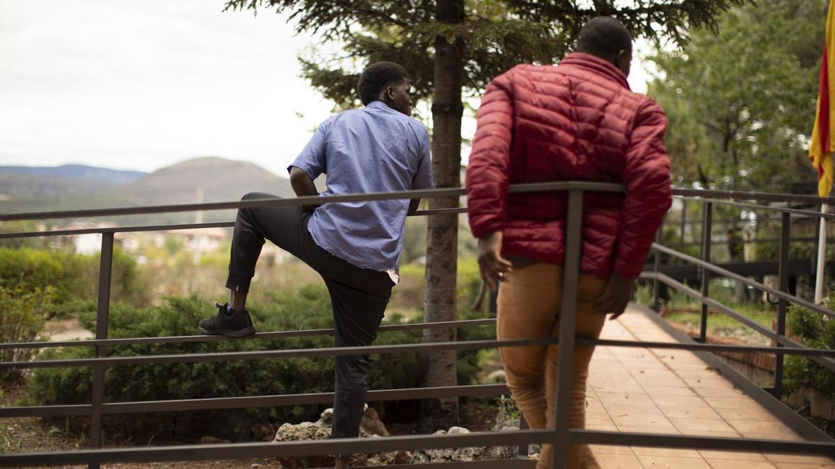 Dos jóvenes refugiados descansan a las puertas del hotel de Mora de Rubielos.