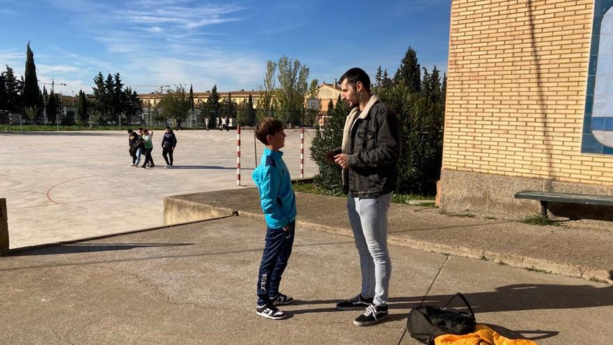 Un alumno habla con un profesor a la hora del recreo en el IES Reyes Católicos.