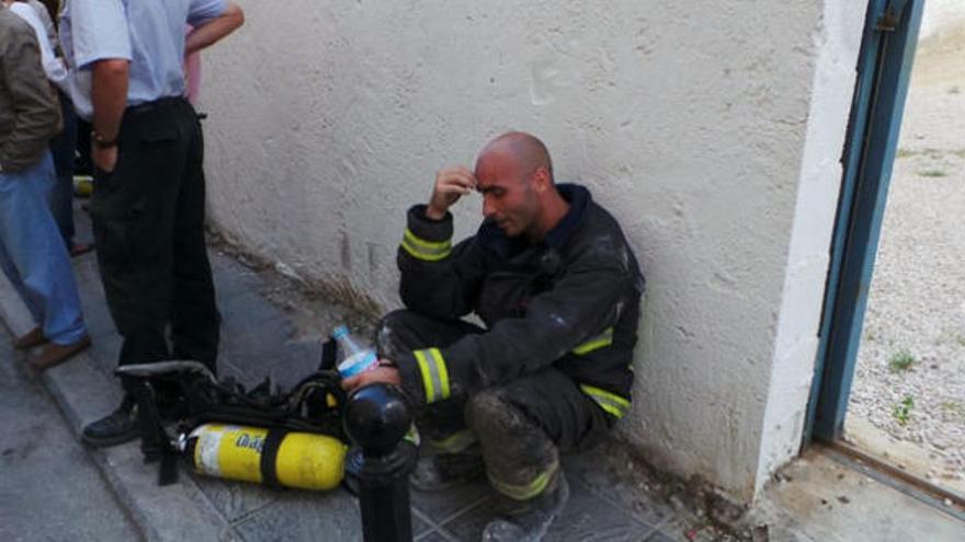 Un bombero, extenuado, tras sofocar el incendio.