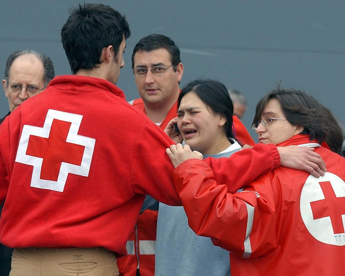 Un equpio de Cruz Roja acompañando a un familiar de una víctima del 11M en la morgue de IFEMA el 11 de marzo de 2004.