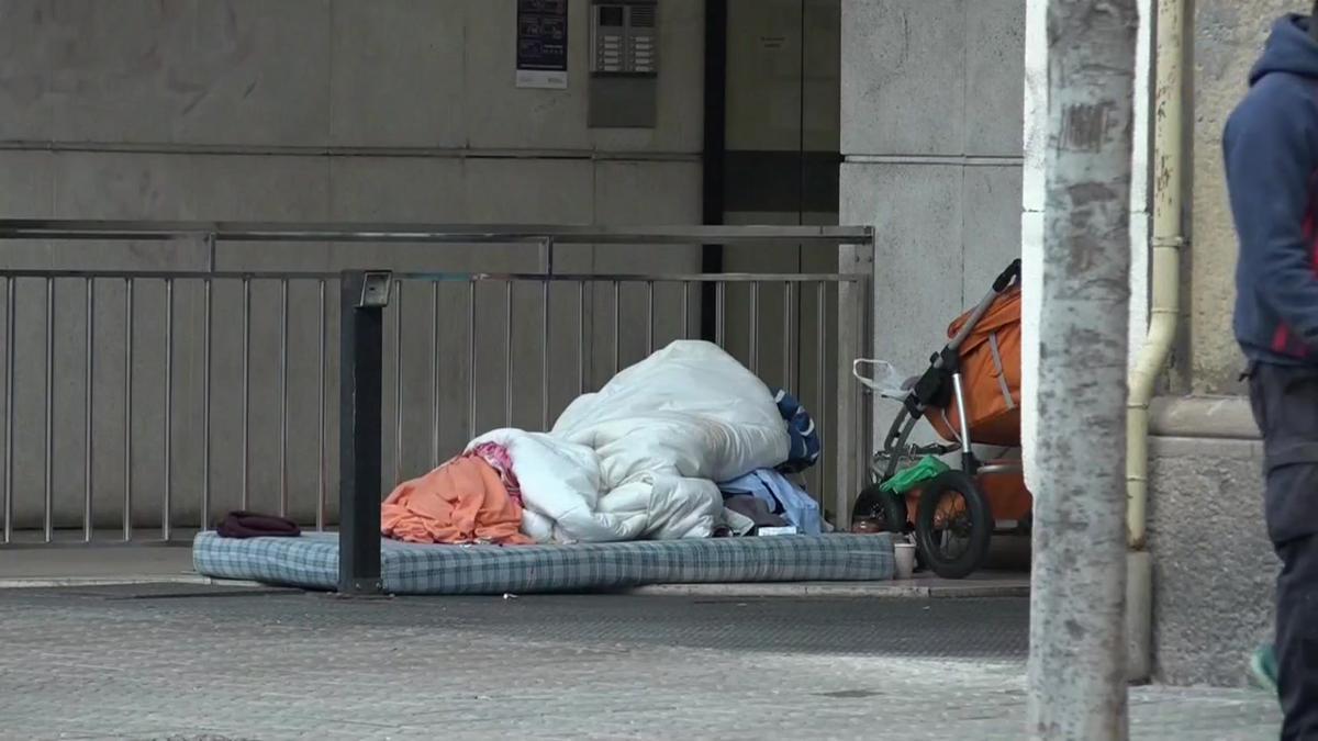 El lugar en el que ha muerto un indigente en la calle de Consell de Cent en Barcelona. En las imágenes se ven aún los enseres del fallecido en la calle. 