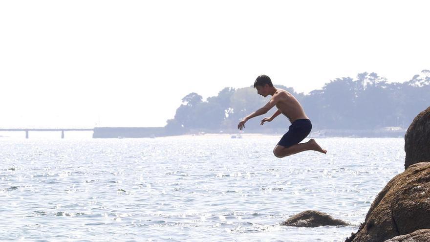 Un joven se lanza al agua desde una roca en Samil // Alba Villar