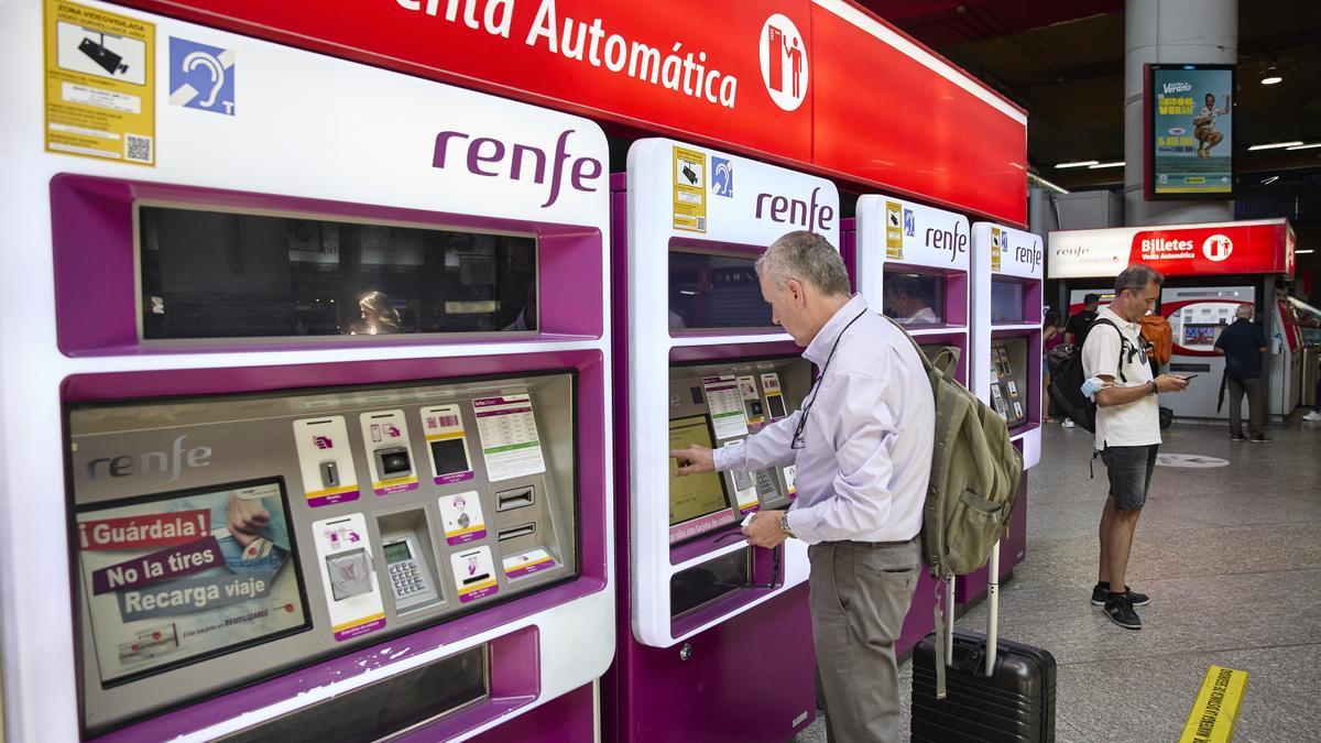 Una persona adquiere un billete en las máquinas de venta de Renfe