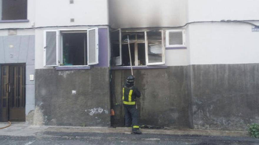 Un bombero municipal trabaja, ayer, en la vivienda siniestrada.