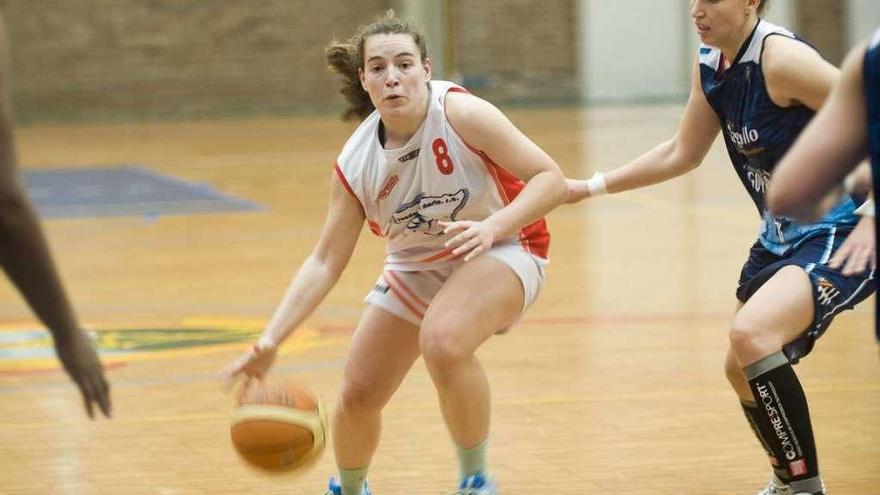 Tatiana Casal bota el balón ante una jugadora rival.