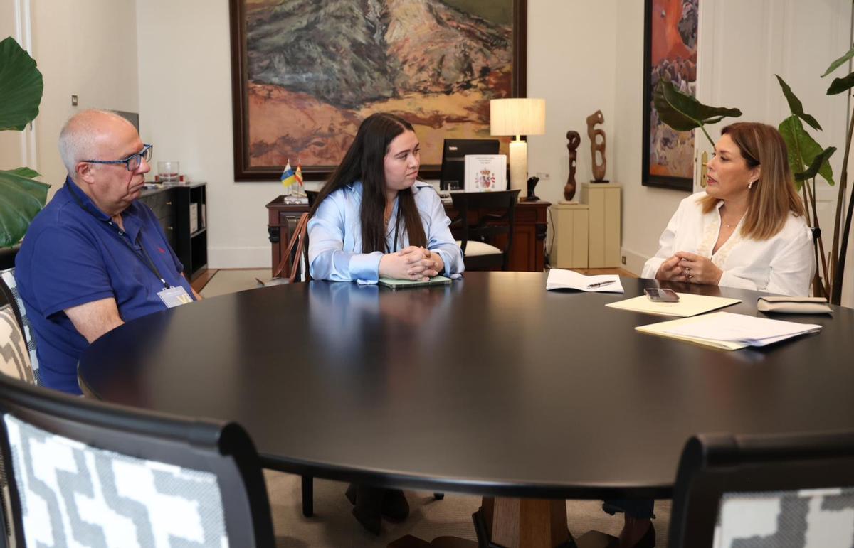 Astrid Pérez (d) con los dos respons que restaura el cuadro oculto.ables de la empresa Cúrcuma