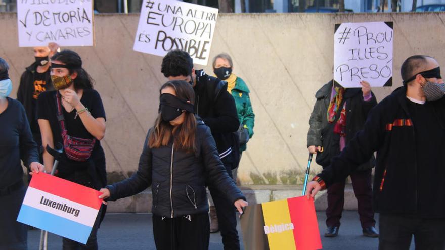 Una noia amb els ulls tapats i aguantant les banderes de Luxemburg i Bèlgica en la protesta de Girona