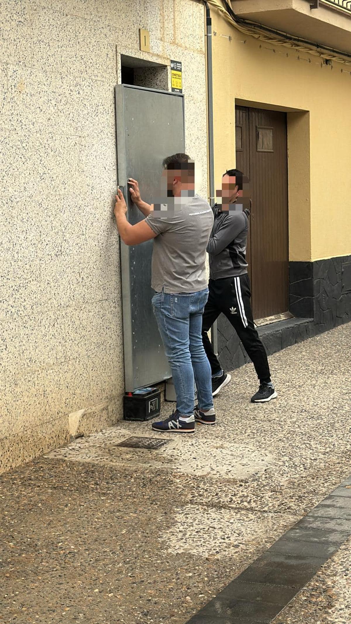Operaris col·locant una porta antiocupa al bloc desallotjat de Llançà