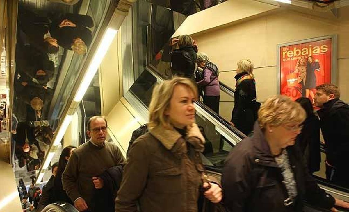 Permanent desfilada de persones per les escales mecàniques d’El Corte Inglés de Barcelona en el tret de sortida inicial de les rebaixes.