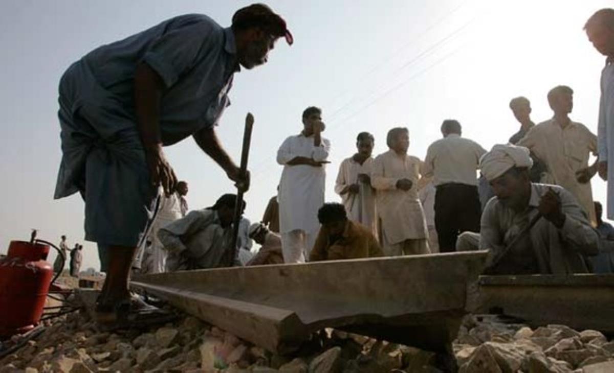 Uns operaris reparen una via de tren destruïda arran de l’explosió a prop de Haidarabad, a la província pakistanesa de Sindh.