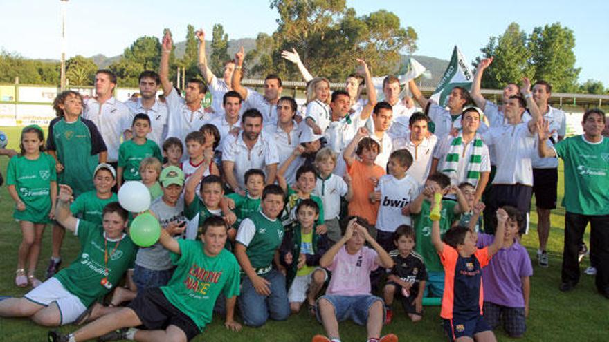 Jugadores, cuerpo técnico y seguidores del Coruxo posan en el campo de O Vao a la llegada de La Roda con el ascenso a Segunda División B. // Joel Martínez