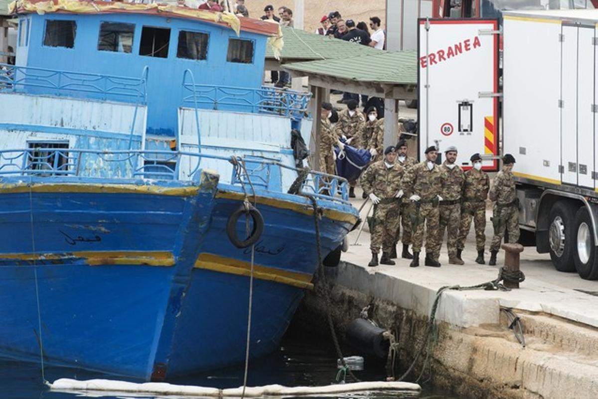 Soldados italianos bloqueando la entrada del barco por donde han guardado los cuerpos que han ido encontrando este domingo