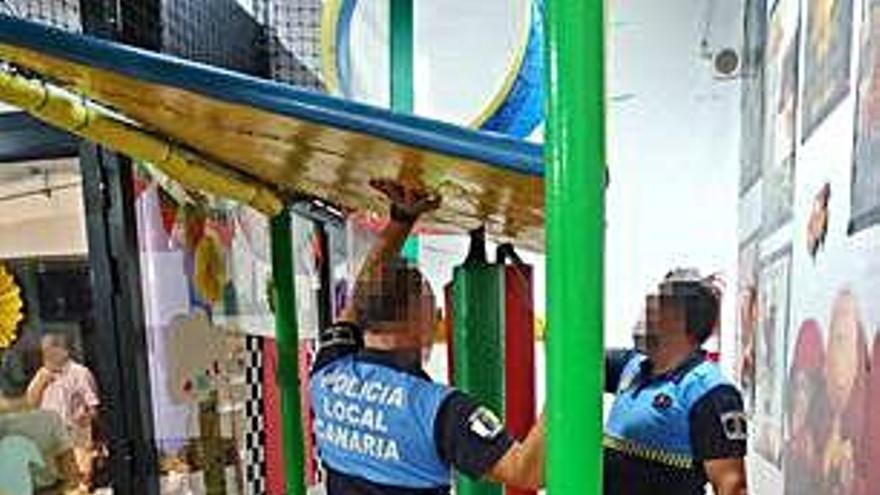 Agentes de la Policía Local junto a la estructura infantil que cedió.