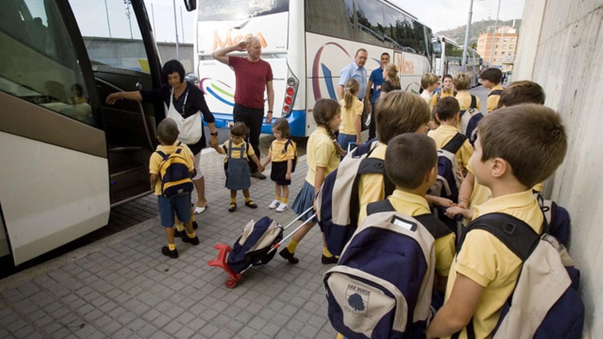 Unos niños, junto a un autobús escolar, en una imagen de archivo.