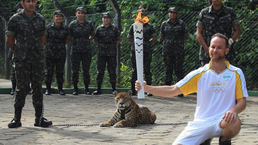 El jaguar, antes de ser abatido, junto a la antorcha olímpica.