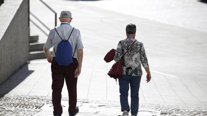 Una pareja arremangada pasea por la plaza Mayor de Cáceres, ayer.