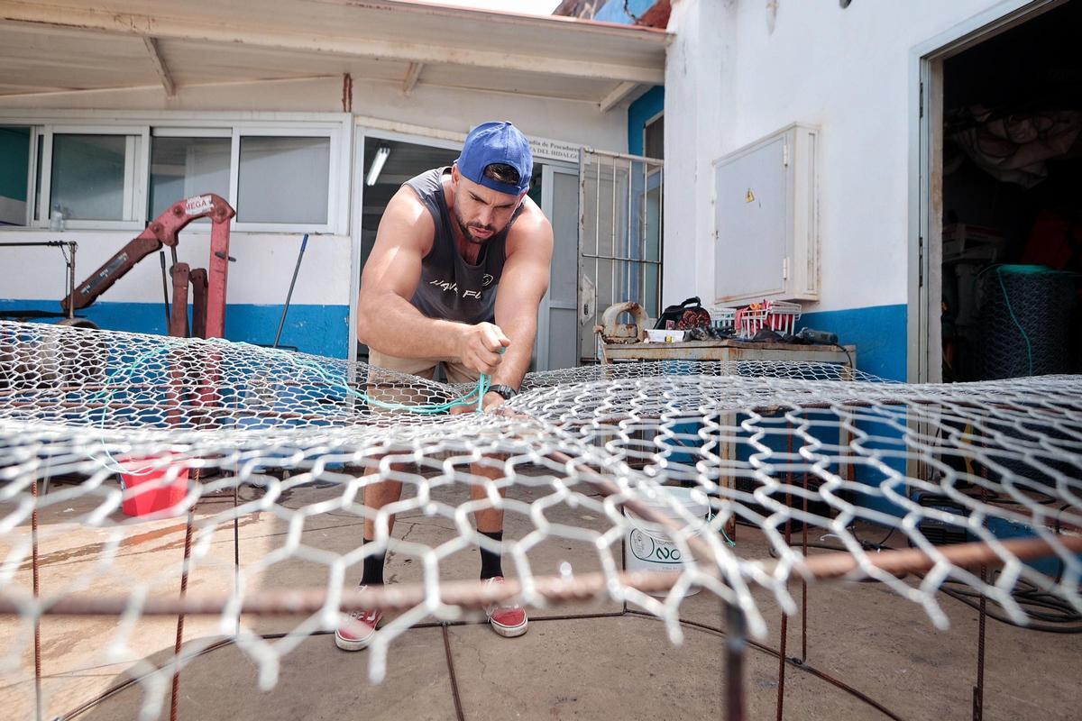 Uno de los cofrades tensando una nasa de pescado