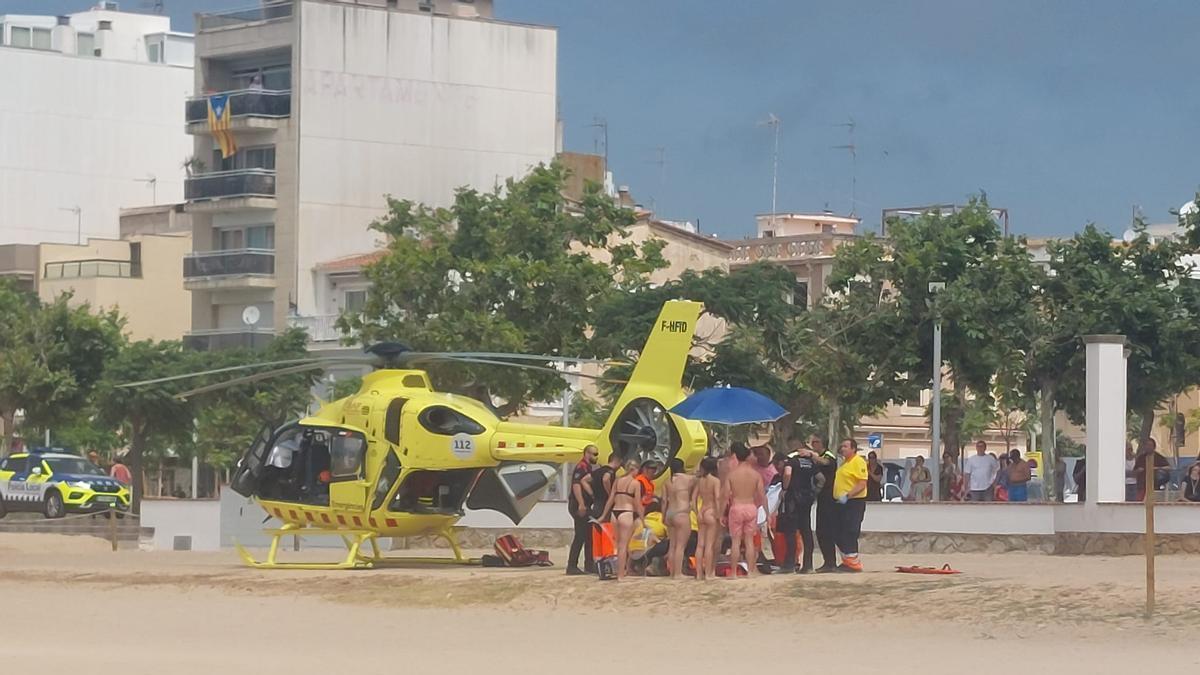 L'helicòpter del SEM, banyistes i policies locals a la platja gran de Palamós per un ofegament no mortal.