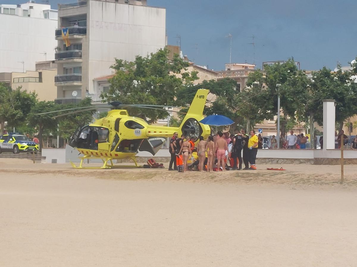 L'helicòpter del SEM, banyistes i policies locals a la platja gran de Palamós per un ofegament no mortal.