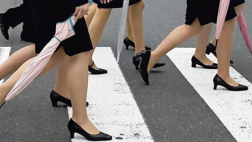Mujeres caminan con tacones.