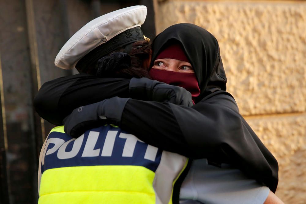 Una portadora del niqab llora mientras la abraza un policía en una manifestación para prohibir en velo en Dinamarca.