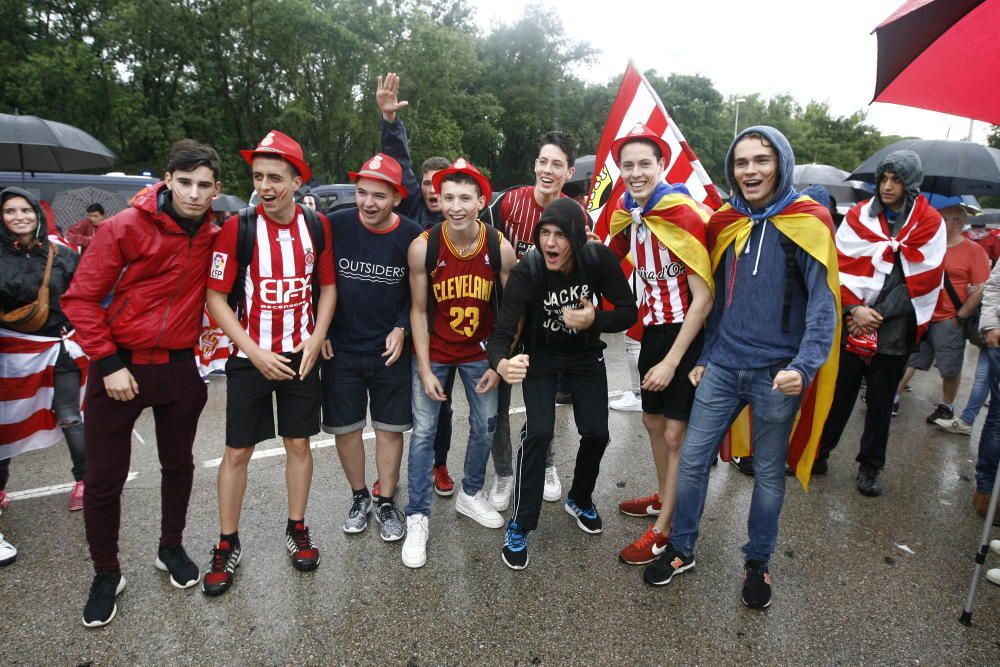 Centenars d'aficionats reben al Girona sota la pluja