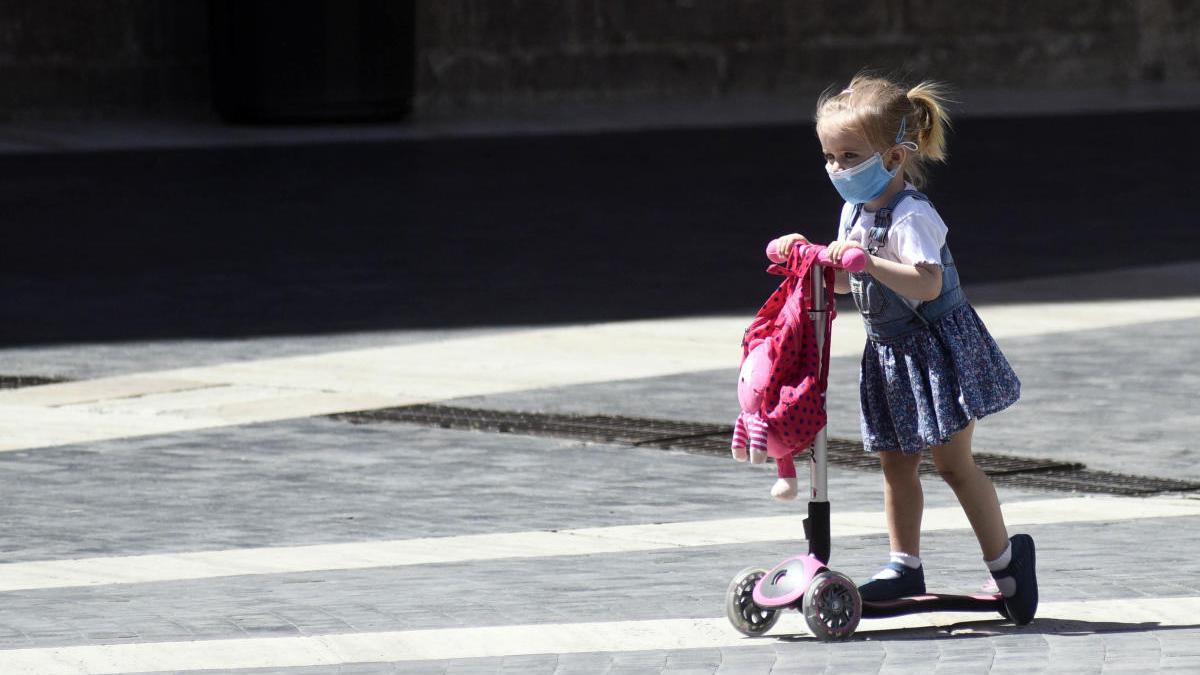 Una niña pasea en patinete por una calle de Murcia.