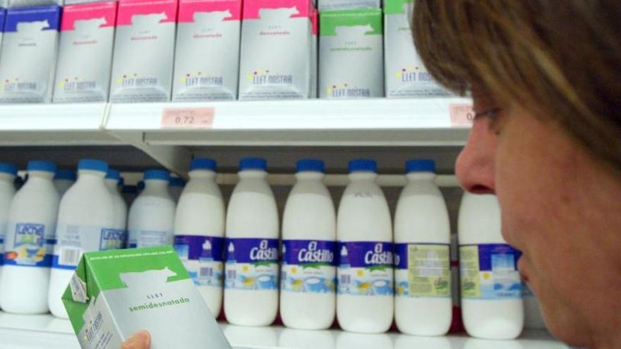 Una consumidora triant la llet en un supermercat