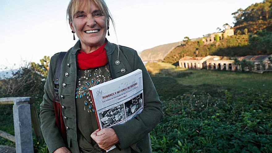 La investigadora Lucía Fandos, con su libro, ante los restos de lo que fue la mina de hierro de Llumeres, clausurada en 1967 por Duro Felguera. | M. V. 